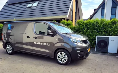 Bedrijfsbus van Installatiebedrijf Koos Kersten met kooskersten.nl op de zijkant, geparkeerd bij een woning